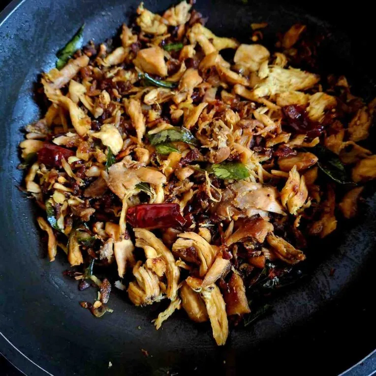 Indian-style shredded chicken fry cooked with spices, green chillies, lemon juice, and curry leaves until crispy.